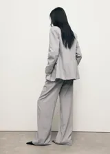 Pantalón de sastreria gris con diseño de raya diplomática, de tiro bajo, corte recto y amplio con pinzas delanteras y trabillas para cinturón.