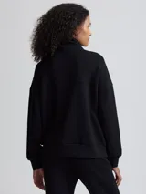 Campera negra de corte holgado con cierre bidireccional, cuello alto y bolsillos frontales.