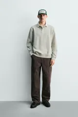 Sudadera de manga larga estilo polo con diseño de rayas horizontales anchas en azul marino y blanco. Presenta cuello de solapa en contraste, cierre frontal con botones ocultos y acabados en rib en puños y bajo.