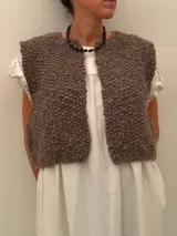 Collar corto de piedras volcánicas negras en la base del cuello, con pequeños detalles en tonos tostados y dorados.