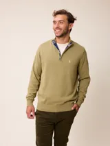 Sweater de punto color gris, con cuello alto y cierre frontal parcial con detalle de tela a cuadros en el interior. Presenta puños y ruedo acanalados y logo bordado en el pecho.