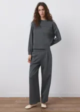 Pantalón de piqué color gris oscuro, de corte recto y holgado con pinzas en la parte delantera y cintura elástica.