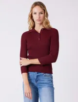 Buzo de tejido acanalado marca Rio & Rian, color beige, con cuello tipo polo con solapa y botones frontales, y mangas tres cuartos.