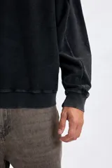 Sudadera de cuello redondo con efecto lavado, color gris oscuro, con estampa tipográfica blanca en la espalda.