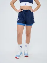 Short deportivo azul marino de mujer con calza interior celeste. Cuenta con cintura elástica ajustable con cordón y detalles de la marca Umbro y del Club Nacional de Football.