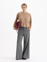 Remera de silueta relajada confeccionada en tela de punto suave. Presenta escote redondo, mangas 3/4, recorte estratégico en la espalda y tajos laterales que aportan movimiento y una caída fluida.