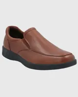 Zapato tipo slip on Hush Puppies de cuero color marrón, con suela negra de poliuretano con tecnología Spinal y plantilla Dual Fit.