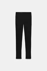 Leggings negros de tiro alto con bolsillos falsos de vivo en el delantero y cierre lateral con cremallera oculta. Presentan cremalleras ocultas en los bajos.