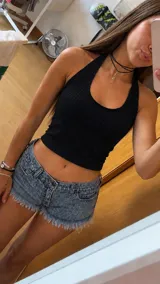 Top negro estilo halter confeccionado en tejido morley elastizado, de corte ajustado y corto.