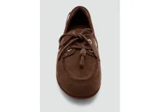 Zapato mocasín de gamuza marrón, estilo náutico, con detalles de cordones con nudo en el empeine, ojales metálicos plateados en los laterales y suela plana.