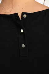 Blusa negra de manga corta y cuello redondo, confeccionada en tejido ligero y fluido.