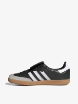 Zapatillas Adidas Samba LT, color negro con las tres tiras blancas y suela de goma marrón.