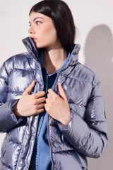 Campera puffer negra con acabado brillante, diseño acolchado, capucha integrada y cierre frontal con botones a presión.