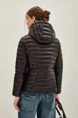 Campera puffer negra con capucha, cierre frontal con doble cremallera y diseño entallado en la cintura.