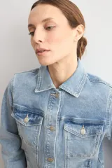 Chaqueta clásica de jean color celeste, con bolsillos frontales con solapa, cierre de botones metálicos y cuello camisero.