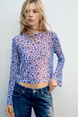 Top de punto fino color lila con estampado de flores abstractas en tonos azules y rojos, con cuello redondo y mangas largas acampanadas.