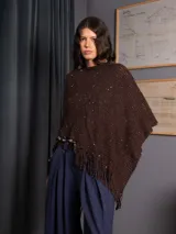 Poncho tejido asimétrico color bordó, con detalle de lentejuelas sutiles y flecos en el ruedo.