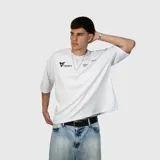 Remera de corte oversize color blanco, con mangas cortas y cuello redondo. Presenta un estampado gráfico minimalista en color negro en el pecho.