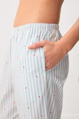 Pantalón largo tipo pijama de algodón, con diseño a rayas celestes y sutiles detalles de puntos rojos, corte recto y bolsillos laterales.