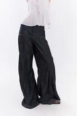 Jean de tiro medio estilo wide leg, confeccionado en denim azul oscuro, con recortes frontales y pespuntes a contratono en color ocre.