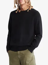 Sweater negro de lana merino de cuello redondo y corte clásico. Tiene puños y dobladillo con punto canalé.