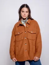 Sobrecamisa color beige de paño con cuello camisero, cierre frontal con botones veteados, dos bolsillos con solapa en el pecho y dos bolsillos laterales.