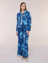 Camperita liviana de silueta entallada, con estampado floral en tonos azules, cuello camisero, cierre frontal con botones y bolsillos en el pecho.
