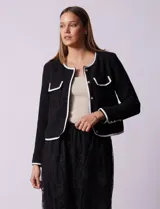 Chaqueta de tweed negra marca Nanette, con escote a la base, abertura central con botones, bolsillos delanteros, aplique de botones perlados en los puños, ribete en contraste blanco y forro interno.