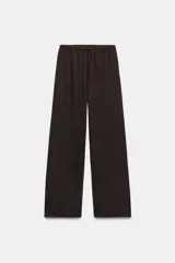 Pantalón rústico color marrón oscuro, de tiro alto, con cintura elástica y cordón ajustable, y pierna ancha.