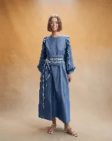 Vestido midi de corte holgado en color verde oliva, con mangas largas abullonadas que presentan detalles de volados en los hombros y puños elásticos.