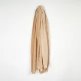 Pashmina de textura ligera y arrugada, color beige, con terminaciones desflecadas en los extremos.