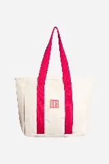Bolso tote de tela canvas color crudo con asas largas a contratono color fucsia. Presenta un logo estampado al frente en color fucsia.