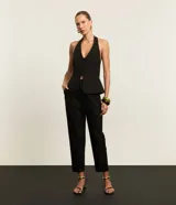 Pantalón de vestir negro, corte carrot (holgado en caderas y ajustado en tobillos), con talle alto, pliegues frontales y cierre tradicional con botón forrado.