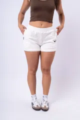 Short deportivo blanco de calce holgado, con cintura elástica y logo bordado en negro.
