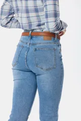 Pantalón jean skinny de tiro alto, color celeste claro, con bolsillos delanteros y traseros, y presillas para cinturón.