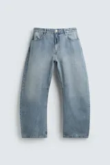 Pantalón jeans de corte relaxed barrel fit, color celeste claro con efecto lavado. Presenta cinco bolsillos, tiro medio, cierre frontal con cremallera y botón, y detalle de pinzas en las rodillas.
