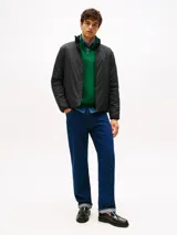 Campera acolchada negra, con cuello alto y cierre frontal de cremallera. Presenta bolsillos laterales con cierre y el logo de Tommy Hilfiger bordado en el pecho.