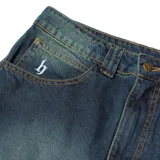 Pantalón de jean azul oscuro con efecto lavado, corte holgado y pierna recta.