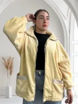 Camperón de mujer color crema, estilo teddy, con cierre frontal y bolsillos laterales.