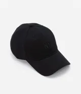 Gorra negra de sarga de algodón, con visera curva y bordado frontal con las letras "NY". Ajuste trasero con hebilla metálica.
