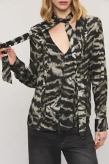 Camisa de viscosa con estampado animal print tipo zebra en tonos negros y grises, con diseño de cuello con lazo integrado, alforzas frontales con volados y mangas largas.