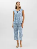 Pijama compuesto por remera sin mangas con escote redondo, botones frontales y detalle de puntilla, acompañado de un pantalón capri con cintura elástica. Presenta un estampado floral en tonos rosados sobre base gris.