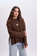 Buzo de punto color marrón con cuello redondo, mangas largas y diseño holgado.