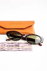 Lentes de sol con armazón ovalado de acetato negro y micas oscuras.