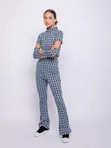 Top de tejido con estampado geométrico retro en tonos celeste, rosa y negro. Es de manga larga con cut out en codos y cuello alto.