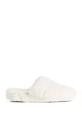 Pantuflas tipo slides forradas en piel sintética, con base de goma de 4 cm de altura y plantilla con logo grabado.