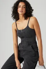 Mono largo de denim negro con corte bustier, tirantes finos y cierre frontal con cremallera.