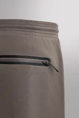 Pantalón jogger relaxed fit Zara Athleticz de tejido técnico compacto elástico con mezcla de algodón. Presenta cintura elástica ajustable con cordón, bolsillos laterales en la cadera, bolsillo trasero con cierre de cremallera, bajo ajustable con elástico y detalle de logo estampado en la pernera.