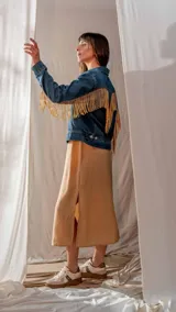 Campera de jean azul con flecos de strass dorados en mangas y espalda.