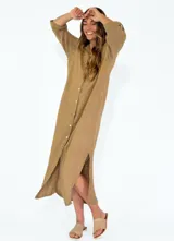 Vestido camisero largo de lino, color mostaza, con cuello camisero, cierre frontal de botones y mangas tres cuartos con detalle de tejido calado en los laterales.